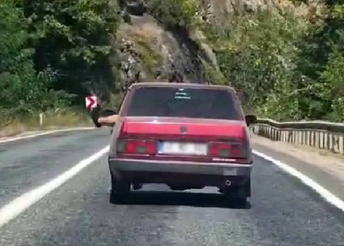 Ayaklarını camdan sarkıtarak trafiği tehlikeye attı